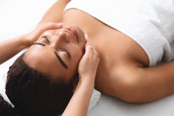istock Pretty black lady having lifting face massage at spa 1284084558