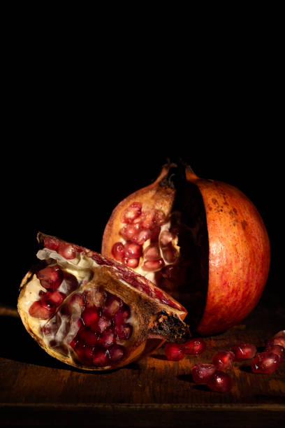 istock Open pomegranate with a quarter to the side and beads. Baroque style still life 1284086567