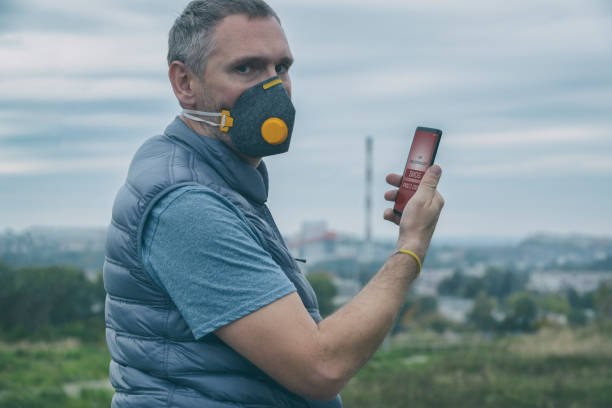 istock Man wearing a real anti-smog face mask and checking current air pollution with smart phone app 1284086769