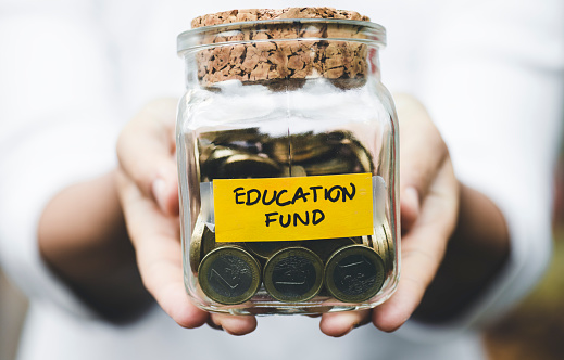 Woman showing education fund jar.