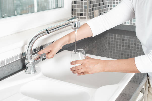 Man washing a cup and dishes in the kitchen sink. Concept of gender equality in household chores.