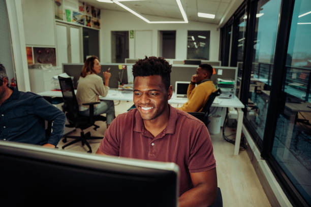 istock Happy businessman working late hours submitting assignments for the week sitting with colleagues in quiet office 1284089369