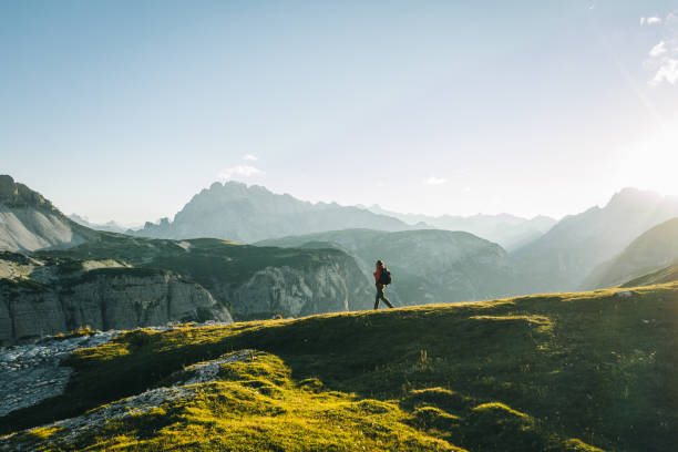 istock Male hiker walks along mountain ridge crest, in distance 1284089973