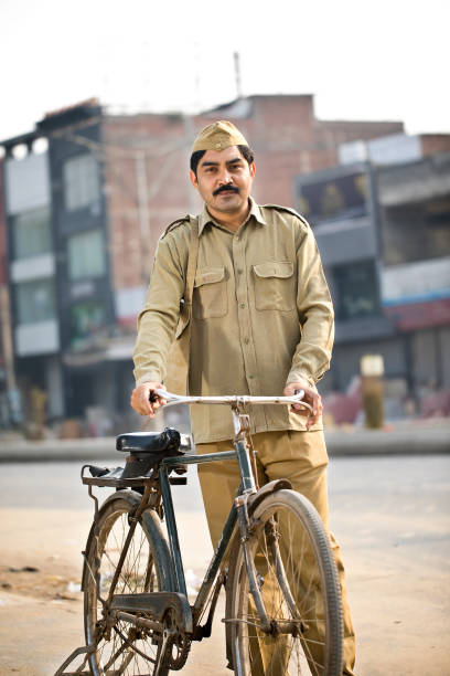 istock Postal worker with bicycle on street 1284090743
