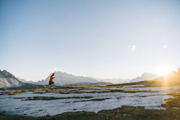 istock Male trail runner traverses mountain ridge crest 1284092874