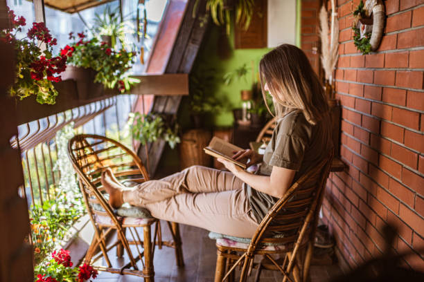istock Woman reading a book on a terrace 1284093680