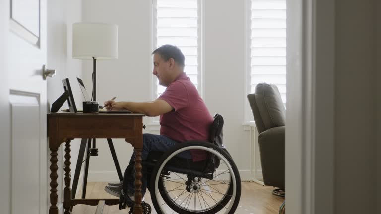 Man in Wheelchair Working in a Home Office