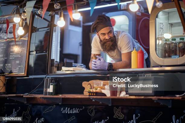Male Employee In Fast Food Service Waiting For Customers Leaned On Desk Stock Photo - Download Image Now