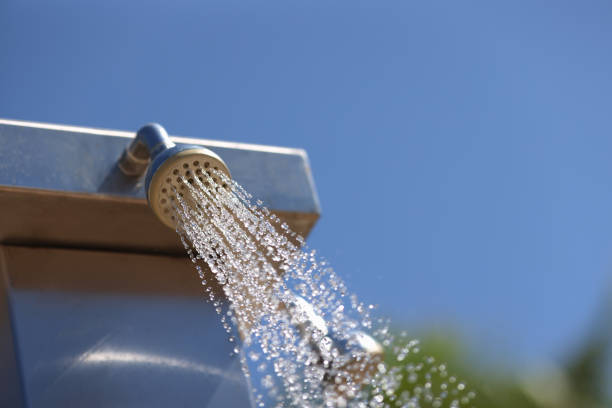Water flows from the shower . Splashing drops of outdoor shower