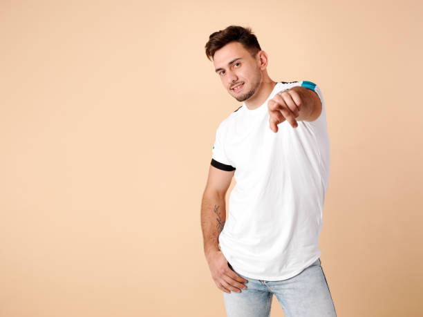 istock Young man smiling and pointing straight ahead with his hand 1284096547