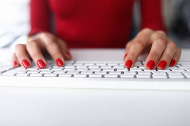 Office worker clicks on the keyboard. girl with Red nail polish works on a computer