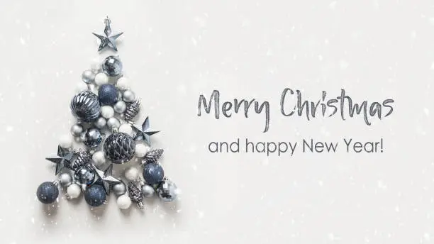 Photo of Christmas tree made of blue balls on grey background. Happy New Year.