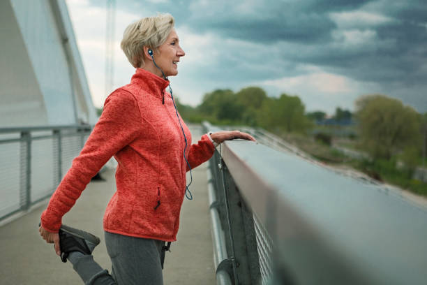 istock Mature woman stretching on a bridge getting ready for running 1284097682