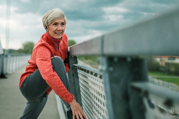 istock Mature woman exercising ,stretching on a bridge getting ready for running 1284097719