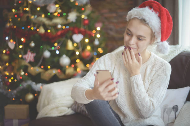istock young woman in christmas interior with smartphone (online dating) 1284101928