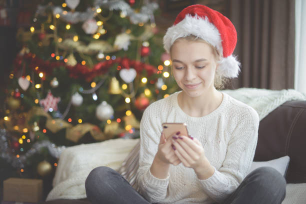 istock young woman in christmas interior with smartphone (online dating) 1284103176
