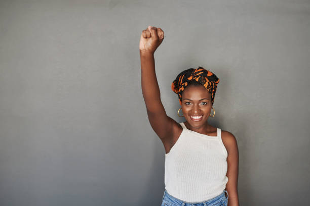 The power is in your hands Studio portrait of a young woman raising her fist against a grey background anti racism photos stock pictures, royalty-free photos & images
