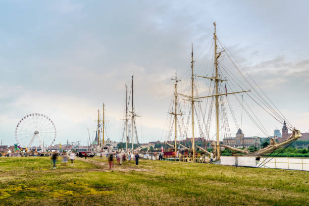 Amusement park and tall ships at Odra River Boulevards. Crowds of tourists enjoying the Days of the Sea festival in Szczecin, Poland
