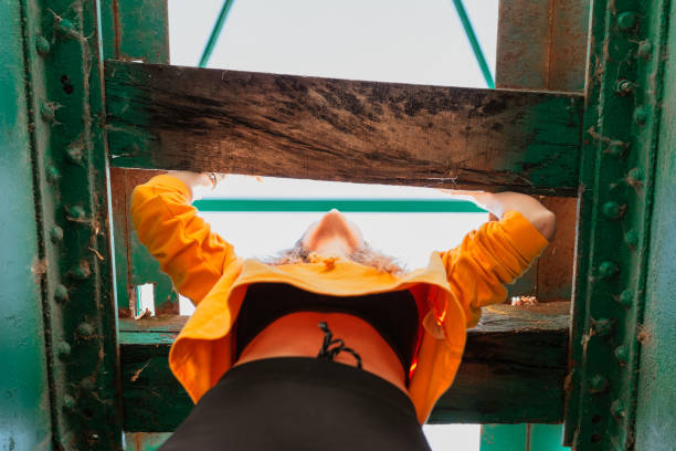 istock Woman has fun exploring an old, abandoned iron railroad bridge 1284106423
