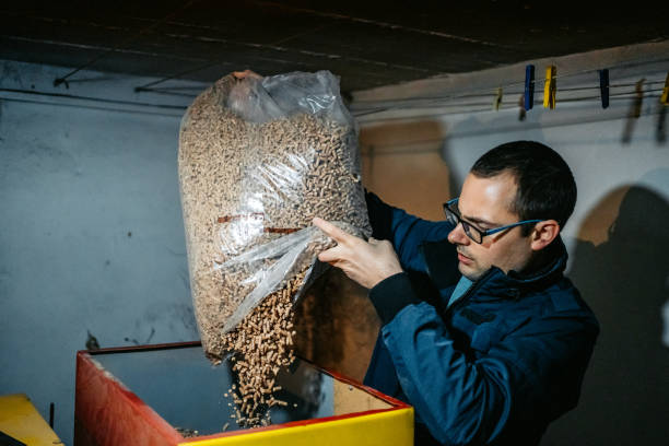 istock Man pouring pellets in pellets boiler 1284107332