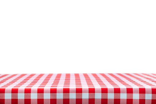 Italian cooking template - blank table with a red checked tablecloth on a white background with copy space.