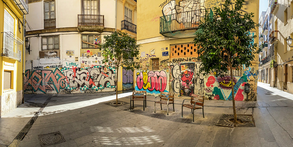 Valencia, Spain - November 2, 2020: Three individual wooden benches to sit down and rest in small plaza in the historic center of the city. There are benches all around the city that allow people to take a moment while walking, specially for seniors