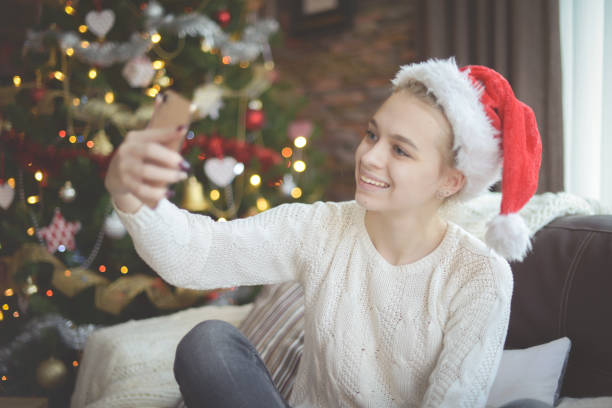 istock young woman in christmas interior with smartphone (online dating) 1284107626