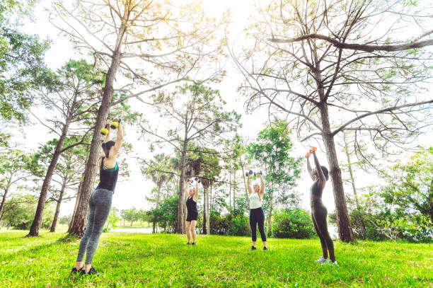 istock Group fitness class women exercising outdoors with weights 1284108609