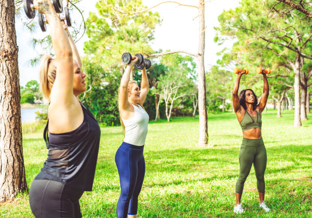 istock Group fitness class women exercising outdoors with weights 1284108672