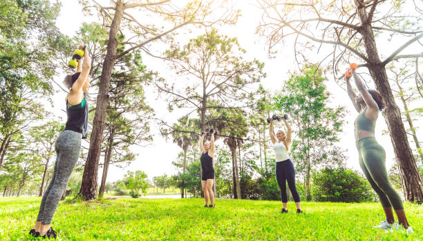 istock Group fitness class women exercising outdoors with weights 1284108703