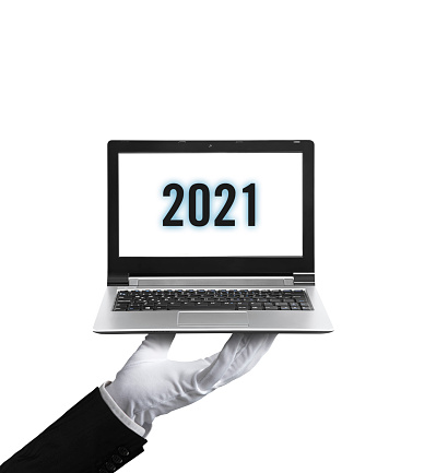 Waiter with gloves holding a laptop quoting “2021” on screen