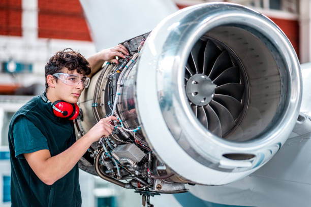 istock Young mechanic maintaining a jet engine in the airplane hangar 1284111943