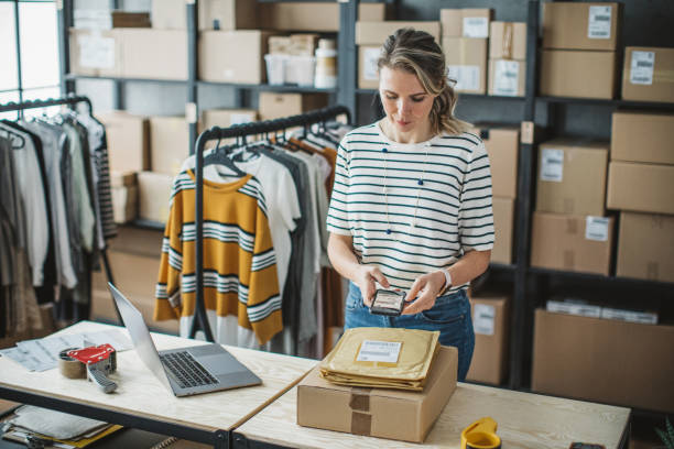 Mature woman running online clothing store Mature woman at online shop. She is owner of small online shop. Receiving orders and packing boxes for delivery. demanding photos stock pictures, royalty-free photos & images