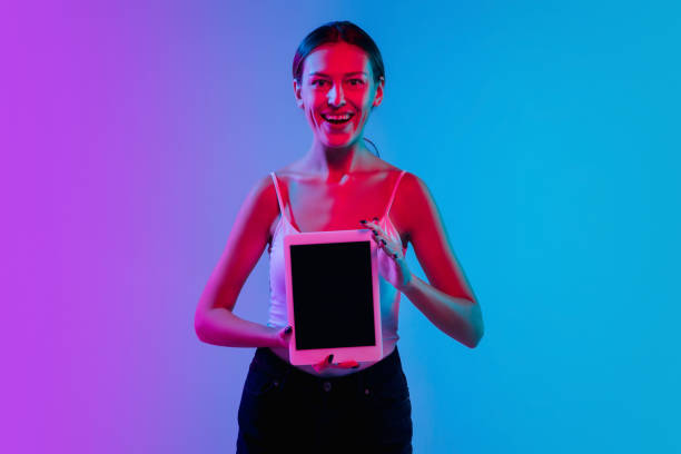 istock Young caucasian woman's portrait on gradient blue-purple studio background in neon light 1284113192