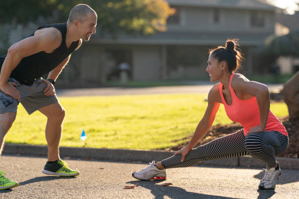 istock Athletic personal trainer and client stretch before workout outdoors 1284114151
