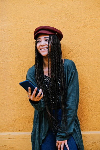 istock black woman with braids using a smartphone outdoors 1284115511