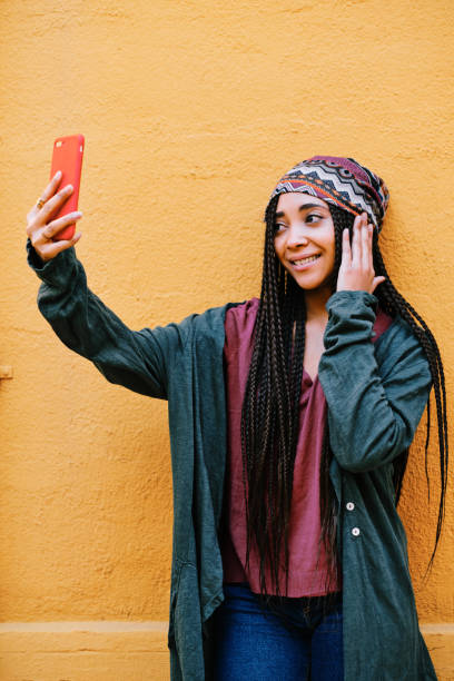 istock black woman with braids using a smartphone outdoors 1284115956