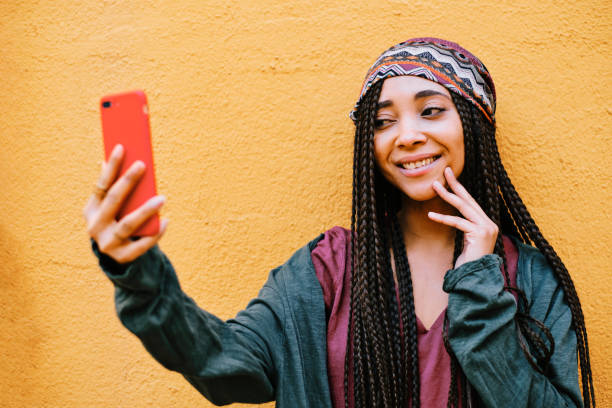 istock black woman with braids using a smartphone outdoors 1284116127
