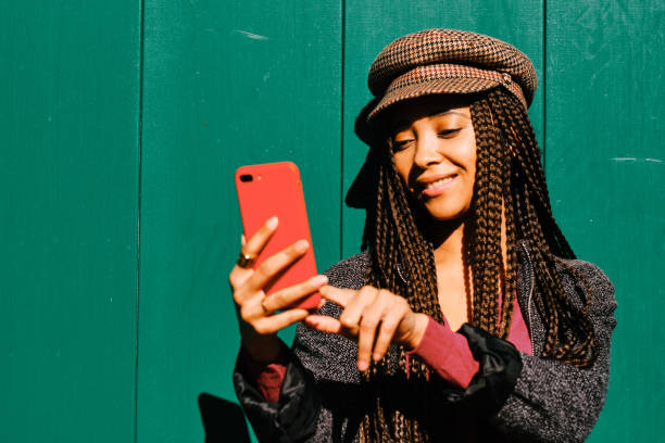 istock black woman with braids using a smartphone outdoors 1284116250
