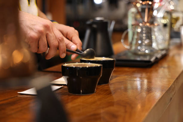 Barista preparing to test and inspecting the quality of coffee Barista preparing to test and inspecting the quality of coffee cupping therapy stock pictures, royalty-free photos & images