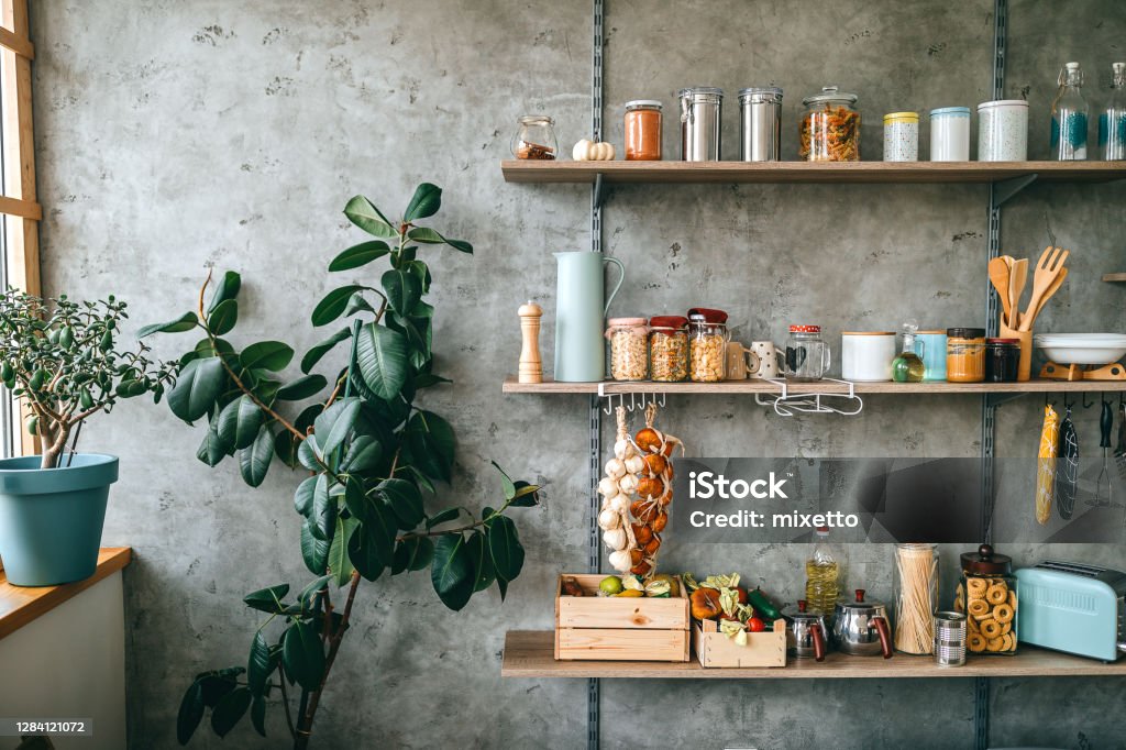 Groceries in glass jars arranged on wooden shelves Uncooked groceries in glass jars arranged on wooden shelves of kitchen Kitchen Stock Photo