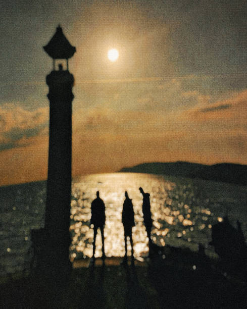 silhuetas de três homens no litoral. - silhouette three people beach horizon - fotografias e filmes do acervo