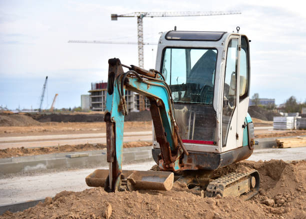 istock Mini excavator digg trench to lay cables concrete curbs and paving slabs at construction site 1284121277