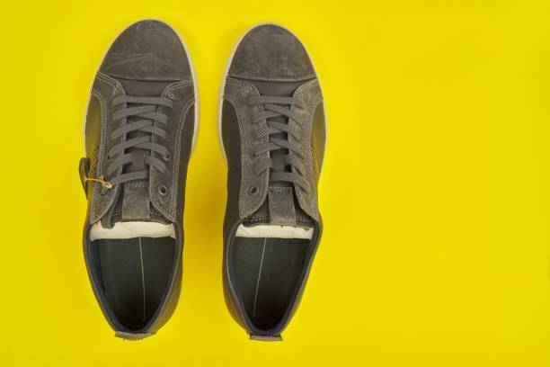 istock New men's leather gray sneakers on yellow background, top view 1284122192