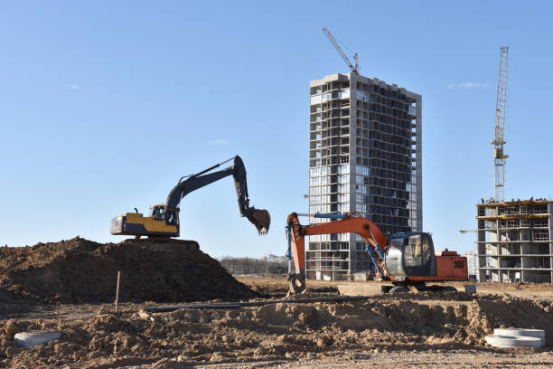 istock Excavator on earthworks at construction site. Backhoe on foundation work and road construction 1284122264