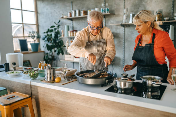 istock Senior couple cooking fish in kitchen 1284123061