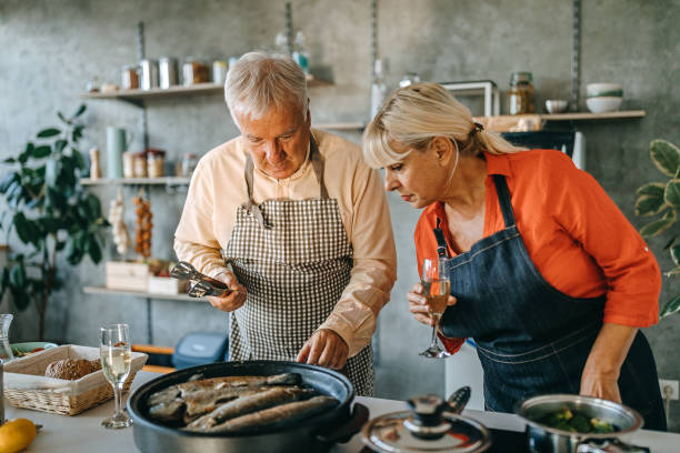 istock Senior couple cooking fish in kitchen 1284123088