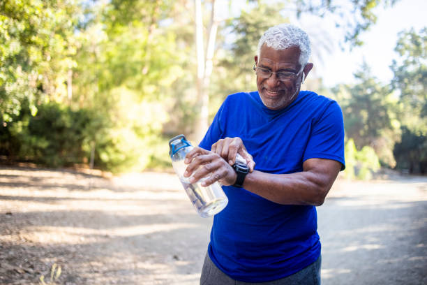senior african american mit fitnessuhr - fitness tracker stock-fotos und bilder