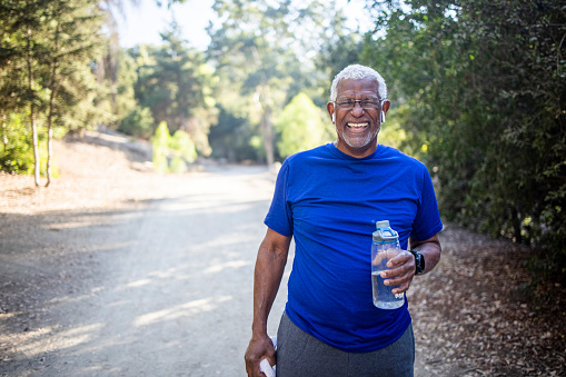A senior African American Man enjoying refreshing water after a workout