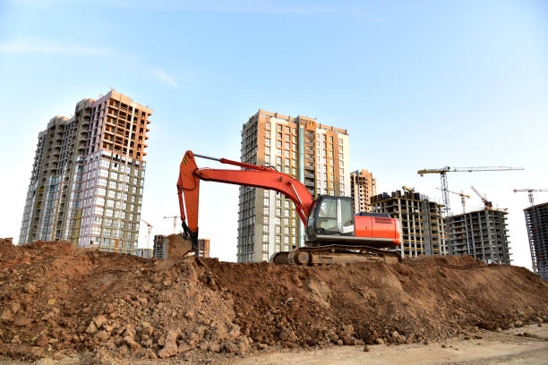 istock Excavator on earthworks at construction site. Backhoe on foundation work and road construction 1284125959